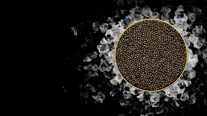 Open caviar tin beside a slice of warm bread on a stone surface, Mediterranean morning light